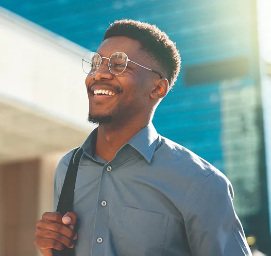 Guy in glasses and grey button up shirt with shoulder bag